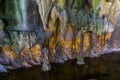 Beautiful scenery in a drip cave, stalagmite stones and water, underground grotto background Royalty Free Stock Photo