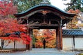 Beautiful scenery of fiery maple trees & a roofed gate of traditional Japanese style at the entrance to Nison-in Temple Royalty Free Stock Photo