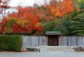 Beautiful scenery of fiery maple trees by the wooden gate & fence at the entrance to the Japanese gardens Royalty Free Stock Photo