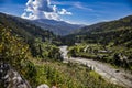 Beautiful scenery of green-covered mountains and a small village under a cloudy blue sky Royalty Free Stock Photo