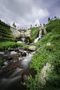 Beautiful scenery of hidden waterfall with cloudy sky in the middle of tea farm at Cameron Highland, Malaysia