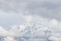 Beautiful scenery of a high rocky mountain covered with snow under a cloudy sky Royalty Free Stock Photo