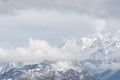 Beautiful scenery of a high rocky mountain covered with snow under a cloudy sky Royalty Free Stock Photo