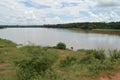 Beautiful scenery of Kamuzu Dam in Lilongwe, Malawi in Africa. African woman is taking water from the lake, surrounded by green