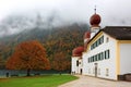 Beautiful scenery of Lake Konigssee with famous St. Bartholomew pilgrimage church & colorful trees Royalty Free Stock Photo