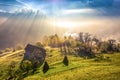 Beautiful scenery landscape Romania village mountains hills fields foggy morning first ray splitting light Royalty Free Stock Photo