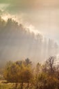 Beautiful scenery landscape Romania village mountains hills fields foggy morning first ray splitting light Royalty Free Stock Photo