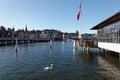 Beautiful scenery of Lucerne City with majestic buildings & hotels by lakeside, a Swiss flag waving by the passenger terminal pier