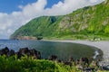 Beautiful scenery of Poco do Bacalhau Waterfall and river with rocky mountain in Flores Island