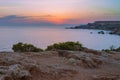 Beautiful scenery of rocky islands with green plants near the calm sea under the colorful sky Royalty Free Stock Photo