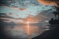 Beautiful scenery of the sandy beach of Moorea island during a cloudy sunset in French Polynesia