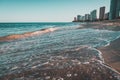 Beautiful scenery of the sea waves splashing on the beach in Ondas with buildings in the background Royalty Free Stock Photo