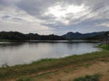 Beautiful scenery of sermo reservoir with green tropical forest and blue sky on a sunny day.