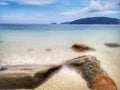 The beautiful silky smooth water waves and rocks on the sea shore. Royalty Free Stock Photo