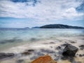 The beautiful silky smooth water waves and rocks on the sea shore. Royalty Free Stock Photo