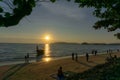 Beautiful scenery sunset with glowing orange light painted on cloudy sky become to twilight dawn, above the sea, long tail boat Royalty Free Stock Photo