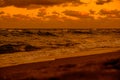 Beautiful scenery of the sunset reflecting on the sea under the golden clouds Royalty Free Stock Photo