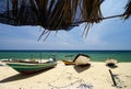 traditional fisherman boat stranded on deserted sandy beach under bright sunny day. Royalty Free Stock Photo