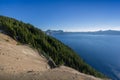 Beautiful scenery of the volcanic cliff with pine trees as seen from the west rim in Crater Lake Royalty Free Stock Photo