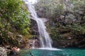 Beautiful scenery of a waterfall flowing into the river in the middle of a rock formation