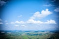 Beautiful scenic background with vignette, blue sky with clouds, landscape and green meadows in a hilly area. Greeting card or
