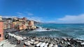 A beautiful scenic beach with colourful clear water and coloured houses.