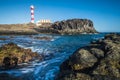 Beautiful scenic landscape with classic lighthouse on the coast and blue ocen and sky in background - concept of travel and Royalty Free Stock Photo