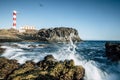 Beautiful scenic landscape with classic lighthouse on the coast and blue ocen and sky in background - concept of travel and Royalty Free Stock Photo