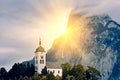 Beautiful scenic sunset over Austrian alps lake. Church on the rock with clouds over Traunstein mountain at the alps lake near