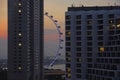 A beautiful scenic view of Singapore flyer attraction behind building blocks under a sunset orange sky evening Royalty Free Stock Photo