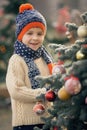 Beautiful school child, boy, decorating Christmas tree on a frosty morning Royalty Free Stock Photo