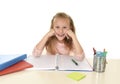 Beautiful schoolgirl with blond hair smiling happy sitting on desk doing homework isolated on white Royalty Free Stock Photo