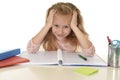 Beautiful schoolgirl with blond hair smiling happy sitting on desk doing homework isolated on white Royalty Free Stock Photo