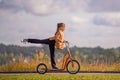 A beautiful schoolgirl girl rides a scooter in an autumn park on a sunny day Royalty Free Stock Photo