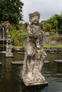 Beautiful sculpture of deity warrior or demon of balinese mythology in majestic park Tirta Gangga on Bali, vertical. Old monument