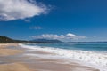 Beautiful sea beach, waves and white foam, sand, blue sky, white clouds. Royalty Free Stock Photo