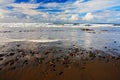 Beautiful sea landscape. The pebble and sand beach at sunrise, with dark blue wave and white clouds, Costa Rica coast. Ocean from Royalty Free Stock Photo