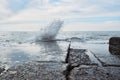 Beautiful sea landscape. Powerful sea wave breaks on stone breakwater during storm and splashes fly in different directions Royalty Free Stock Photo