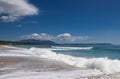 Beautiful sandy beach, sea waves, foam, blue sky, white clouds. Royalty Free Stock Photo