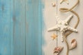 Beautiful sea stars, shells, rope and sand on blue wooden background, flat lay. Space for text Royalty Free Stock Photo