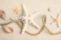 Beautiful sea stars, shells and rope on sand, flat lay Royalty Free Stock Photo
