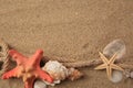 Beautiful sea stars, shells and rope on sand, flat lay. Space for text Royalty Free Stock Photo