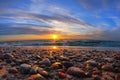 Beautiful sea sunset and sun glare on wet pebbles Royalty Free Stock Photo