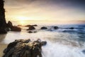 beautiful sea view scenery over stunning sunrise background.sunlight beam and soft wave hitting beach rocks Royalty Free Stock Photo