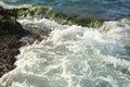 Beautiful sea wave background with green rock shore and foam near the seashore. Contrast color portrait