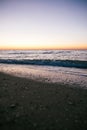 Beautiful sea waves foam closeup and sandy beach with seashells in sunrise light on tropical island. Waves in ocean at sunset. Royalty Free Stock Photo