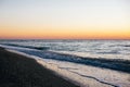 Beautiful sea waves foam closeup and sandy beach with seashells in sunrise light on tropical island. Waves in ocean at sunset. Royalty Free Stock Photo