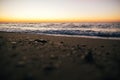 Beautiful sea waves foam closeup and sandy beach with seashells in sunrise light on tropical island. Waves in ocean at sunset. Royalty Free Stock Photo