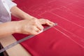 A beautiful seamstress woman in her own atelier makes a pattern