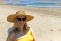 Beautiful seascape with a girl, slender girl in a hat and swimsuit relaxes and lies on a sun lounger